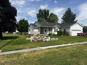 Ranch-style house featuring a porch, an attached garage, and a shingled roof