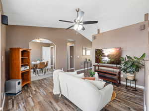 Living room with arched walkways and vaulted ceiling,