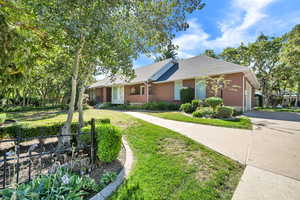 Ranch-style house featuring driveway, brick siding, and a shingled roof