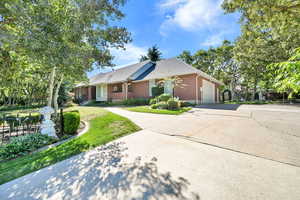 Single story home featuring concrete driveway, brick siding, a garage, and a front lawn