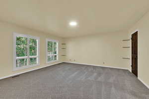 Spare room featuring baseboards and light carpet