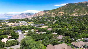 Aerial view of property's location with nearby suburban area and a mountainous background