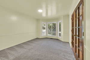 Unfurnished room featuring ornamental molding, light colored carpet, and a textured ceiling