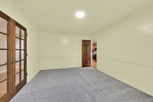 Unfurnished room featuring french doors, carpet flooring, and ornamental molding