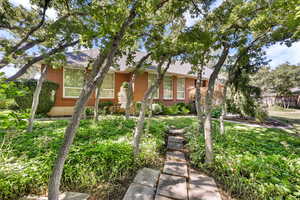 View of front of property featuring brick siding and a shingled roof
