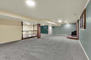 Finished basement with carpet floors and recessed lighting