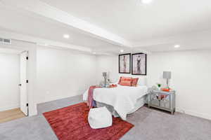 Carpeted bedroom with recessed lighting and beamed ceiling