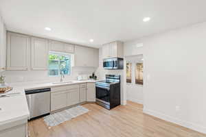 Kitchen with stainless steel appliances, recessed lighting, light wood-type flooring, and light countertops