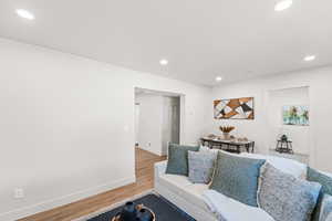 Living room with recessed lighting and light wood-type flooring