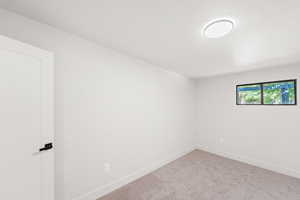 Carpeted spare room featuring baseboards