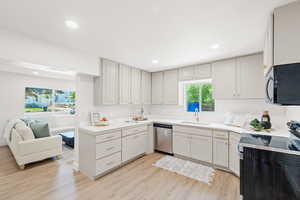 Kitchen featuring stainless steel appliances, light wood-style flooring, recessed lighting, open floor plan, and light countertops