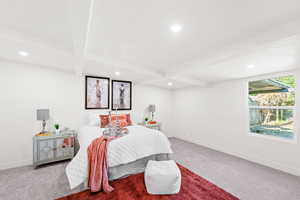 Carpeted bedroom with recessed lighting and beamed ceiling