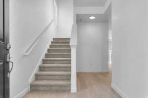 Staircase with wood finished floors and a textured ceiling