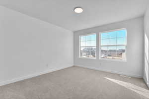 Unfurnished room with a textured ceiling and light carpet