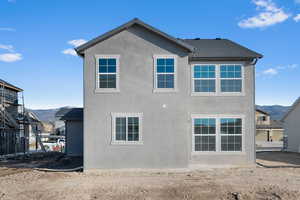 Back of house featuring stucco siding and a mountain view