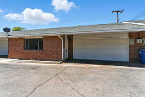 Ranch-style house with a shingled roof, brick siding, and a garage