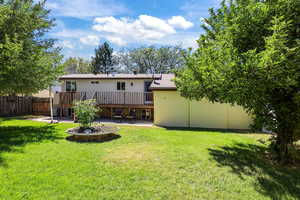 Back of house with a patio, a wooden deck, and a shingled roof