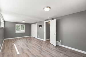 Spare room featuring light wood-type flooring and baseboards