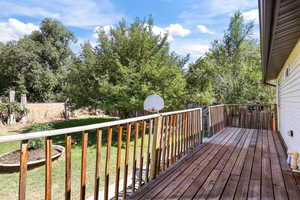 Wooden terrace featuring a yard