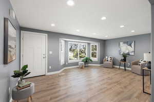 Foyer with light wood-style floors and recessed lighting