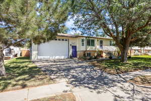 View of front of house with driveway, an attached garage, and stairway
