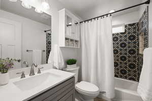Full bathroom featuring shower / bath combination with curtain and vanity