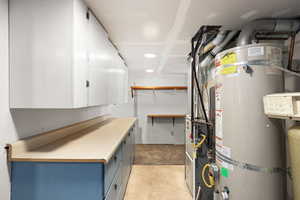 Utility room featuring strapped water heater