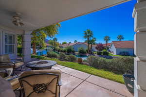 View of patio featuring an outdoor fire pit, ceiling fan, and a residential view