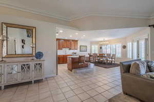 Kitchen featuring light tile patterned flooring, open floor plan, brown cabinetry, recessed lighting, and a kitchen island