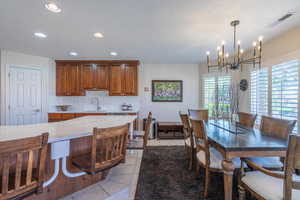 Dining room featuring light tile patterned floors, a textured ceiling, recessed lighting, and a chandelier