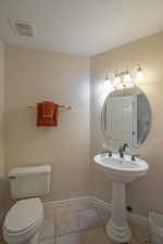 Half bathroom with light tile patterned floors and a textured ceiling