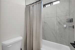 Full bath with shower / bathtub combination with curtain and toilet