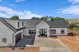 Modern farmhouse featuring a metal roof, french doors, stucco siding, and a standing seam roof