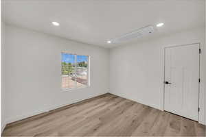 Empty room with recessed lighting and light wood-style floors