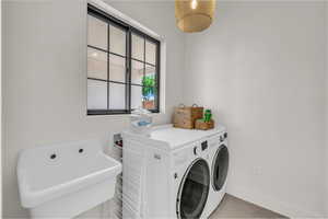 Laundry area featuring separate washer and dryer and baseboards