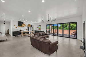 Living room featuring concrete floors, recessed lighting, and a chandelier