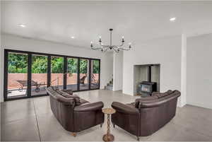 Living area featuring a wood stove, recessed lighting, stairs, and a chandelier