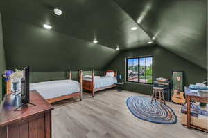 Bedroom featuring lofted ceiling, wood finished floors, and recessed lighting