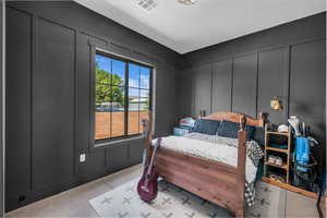 Bedroom featuring a decorative wall and light carpet