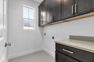 Laundry area featuring hookup for a washing machine, hookup for an electric dryer, and cabinet space