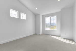 Spare room with carpet flooring, recessed lighting, a mountain view, and lofted ceiling