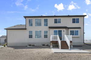 Rear view of property with stucco siding