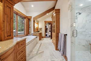 Bathroom featuring vanity, a marble finish shower, a bath, recessed lighting, and light marble finish floors