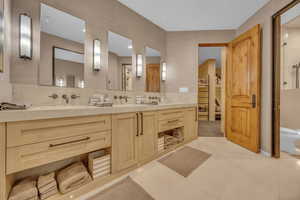 Bathroom featuring double vanity, a shower stall, light tile patterned flooring, a walk in closet, and backsplash