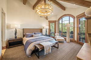 Bedroom with high vaulted ceiling, beam ceiling, a chandelier, and access to outside