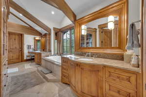 Bathroom with two vanities, a bath, light tile patterned floors, and recessed lighting