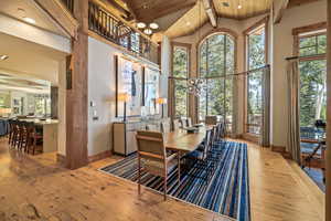 Dining space with a chandelier, light wood finished floors, a wood ceiling with exposed beams, high vaulted ceiling, and recessed lighting