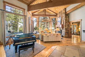 Living area featuring a wooden ceiling with exposed beams, light wood-style floors, and high vaulted ceiling