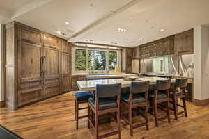 Kitchen featuring a kitchen bar, recessed lighting, light wood-type flooring, a center island, and light stone countertops