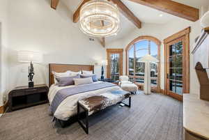 Bedroom with beamed ceiling, a chandelier, access to exterior, and high vaulted ceiling
